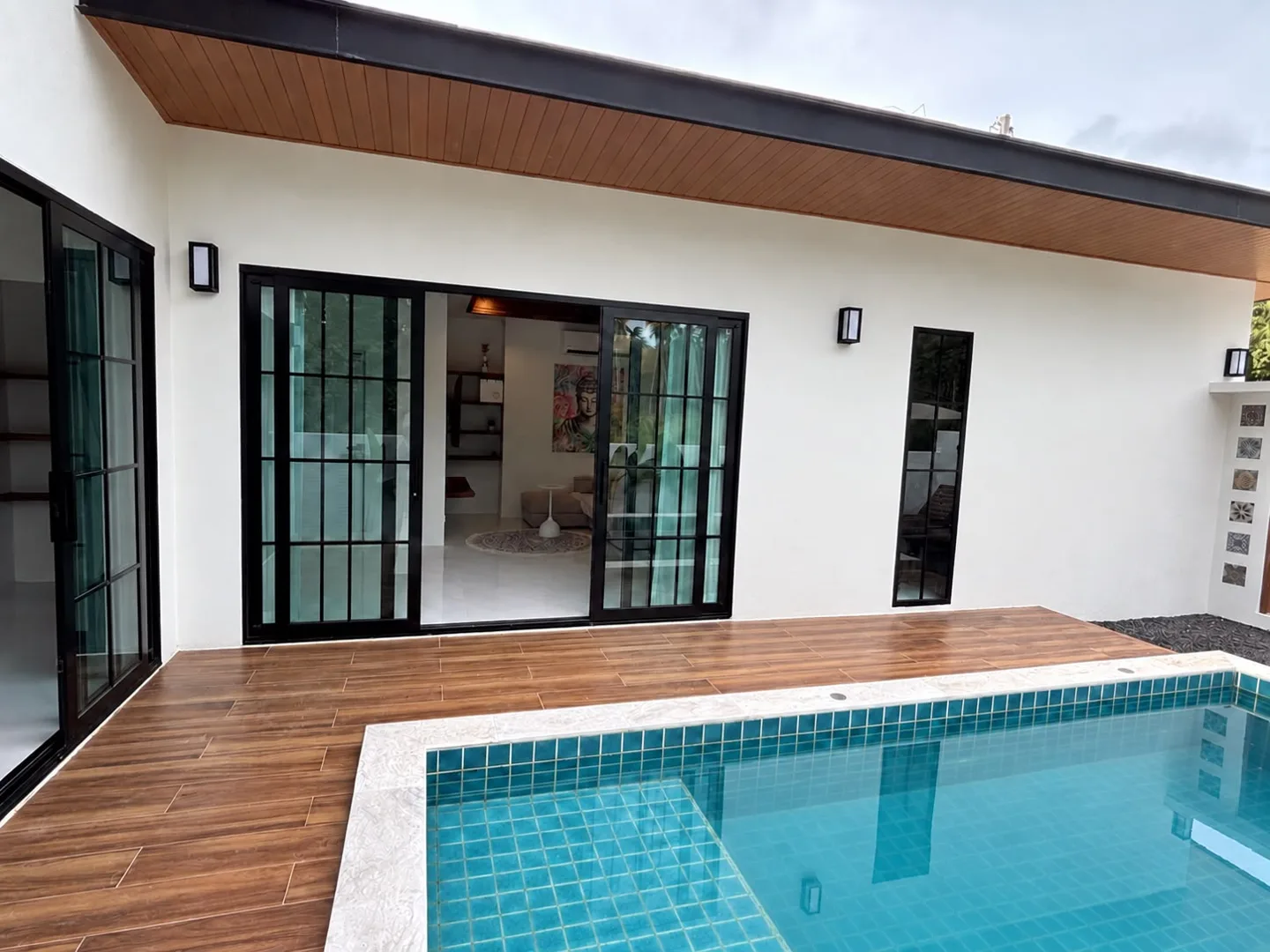 Completed white villa opening onto its private pool and deck